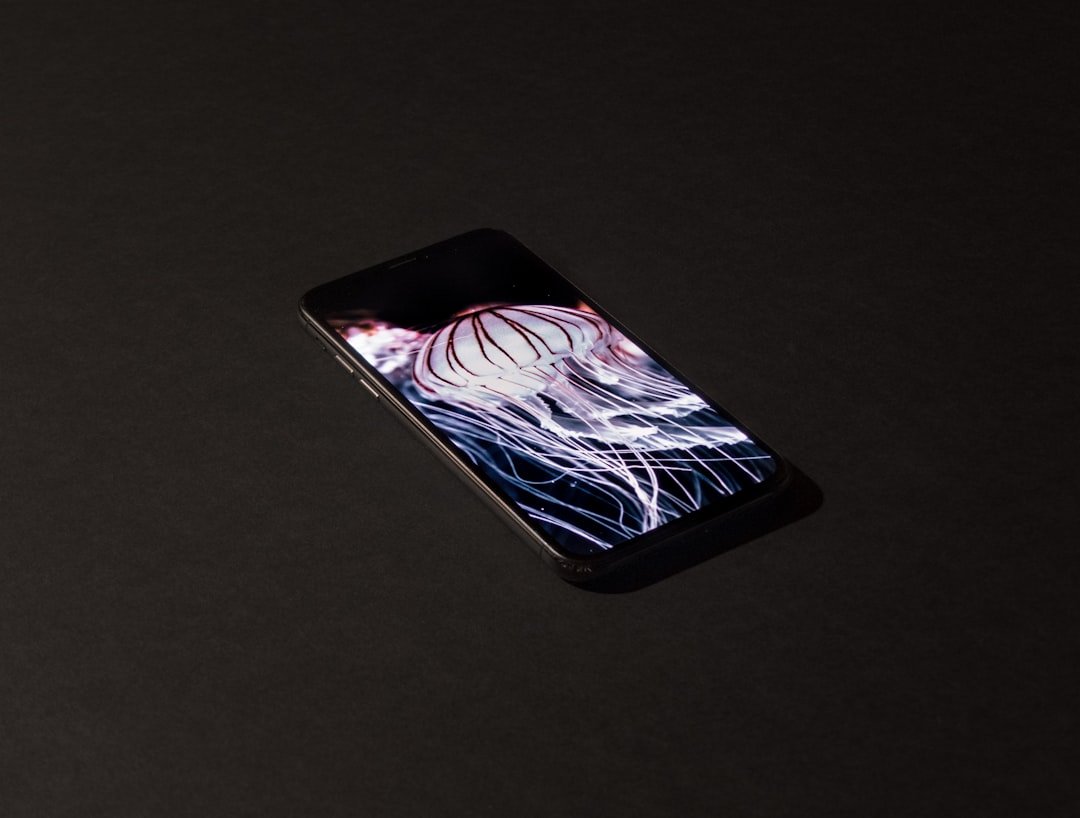 Imagem de uma pessoa segurando um celular com um design gráfico na tela